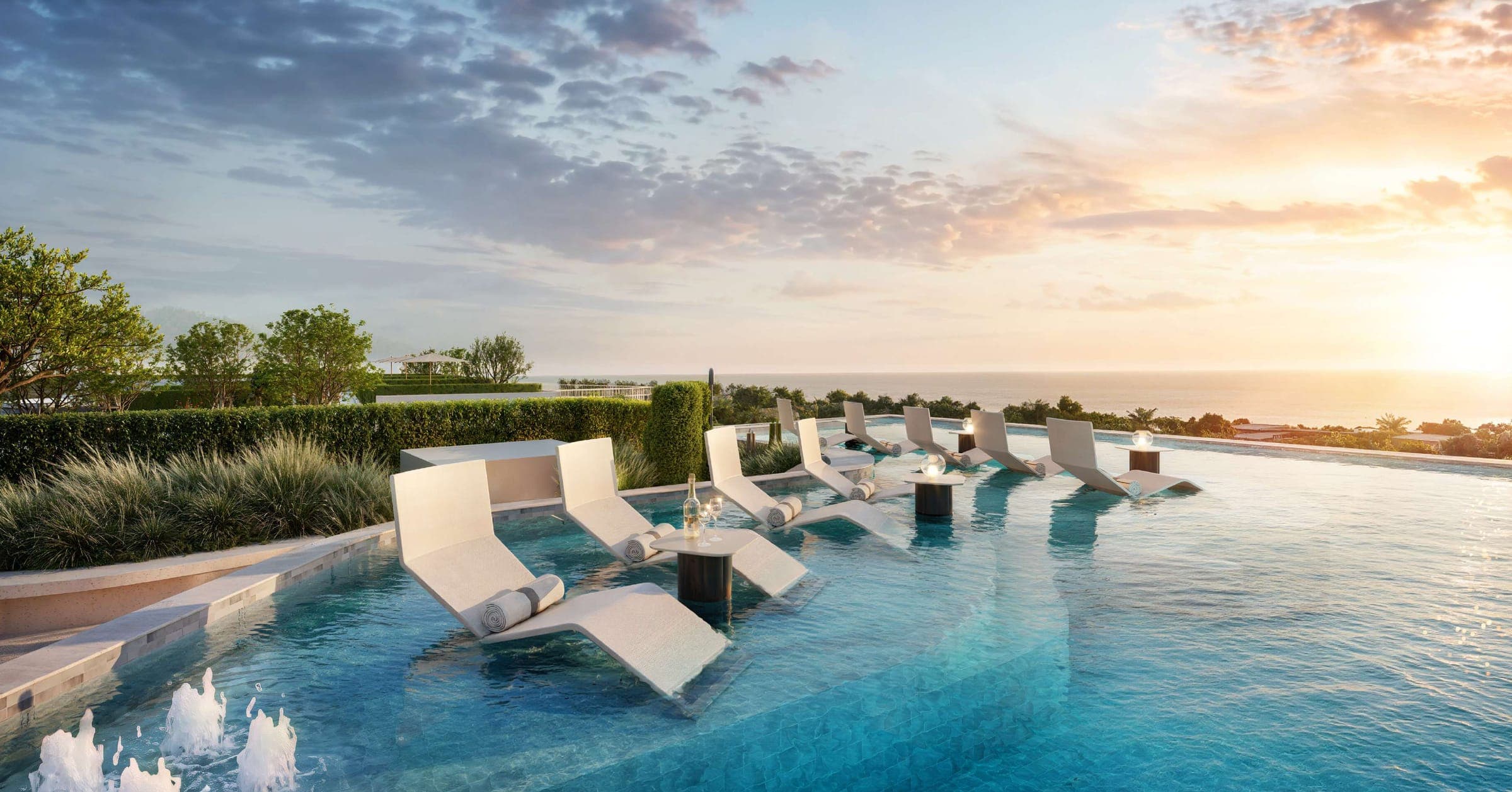 The Kuartz rooftop sky pool with in-water loungers facing the sea at sunset