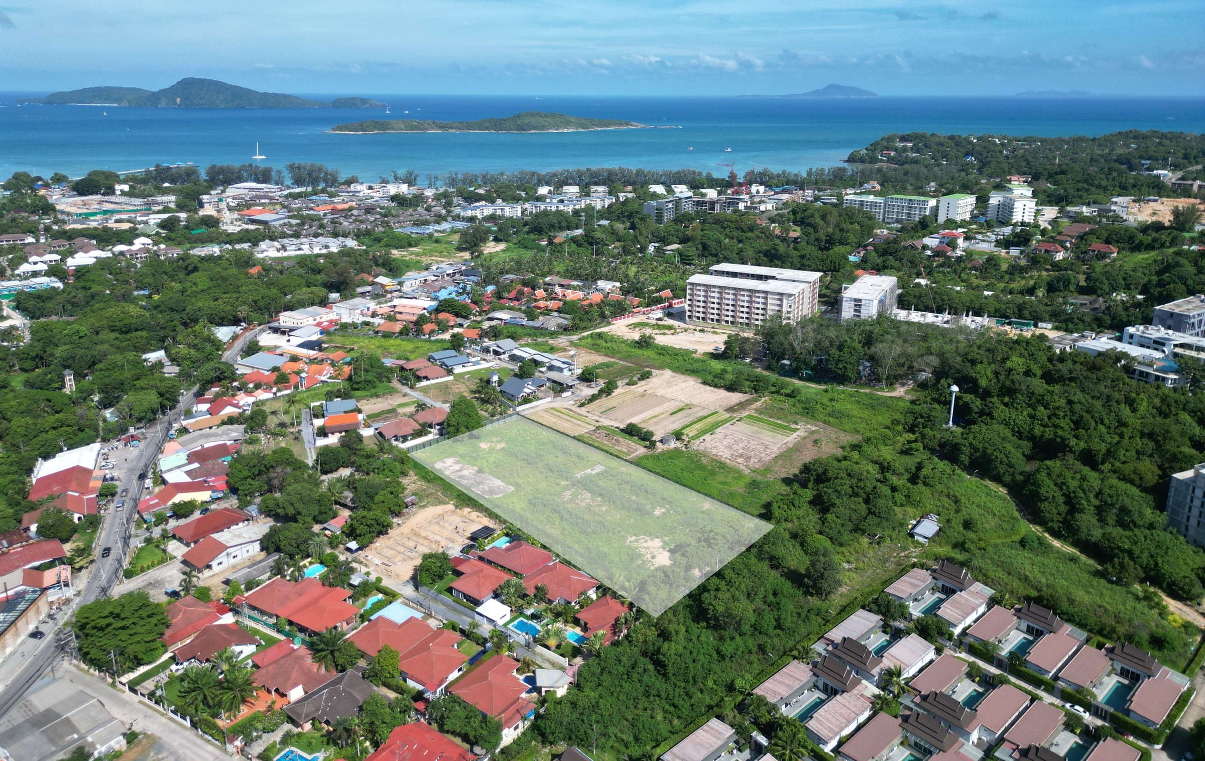 Aerial photograph of the project site in Nai Harn, with the sea and islands beyond