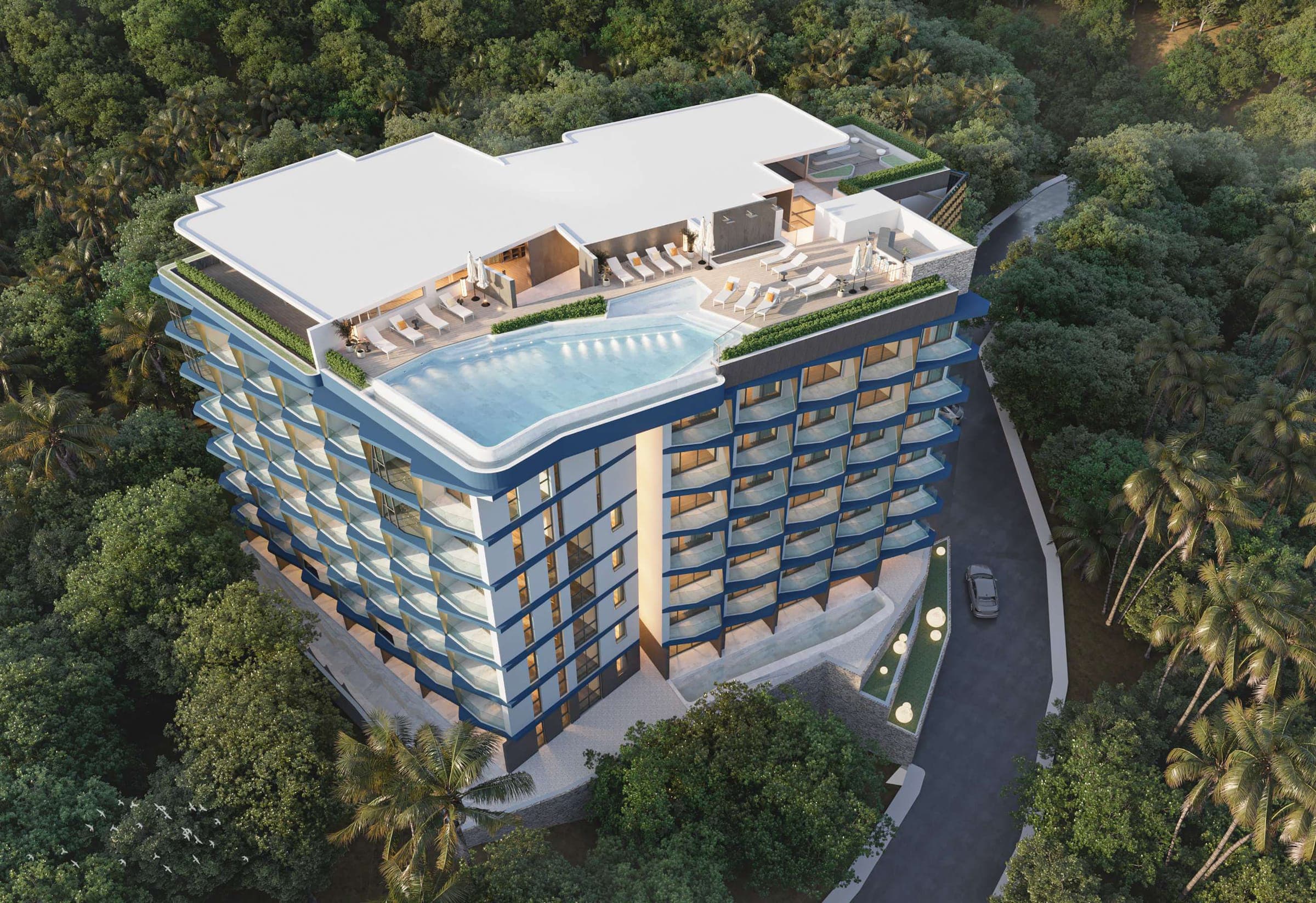 Aerial view of Ashiyana Heights and its rooftop infinity pool on a forested hillside