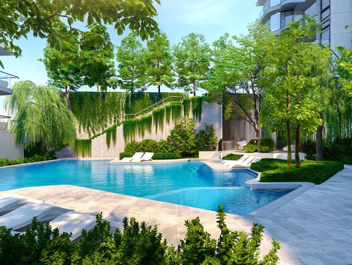 Free-form pool with loungers among trees and a planted wall